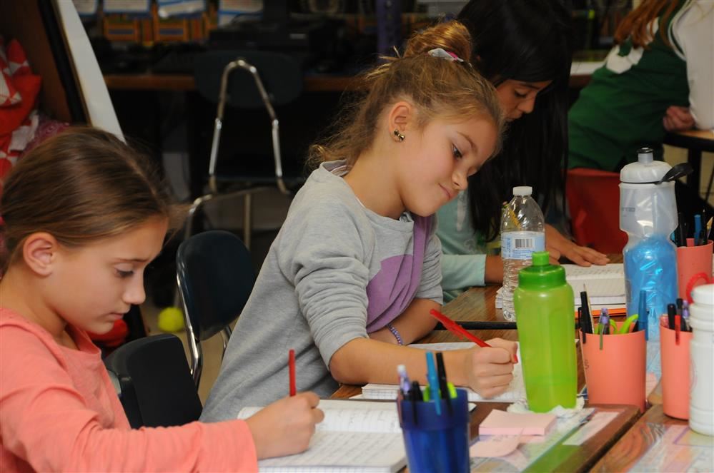 2 female students writing and studying