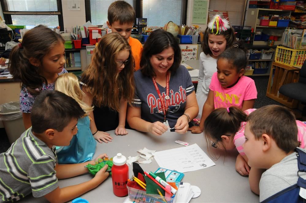 teacher and students working on classroom project
